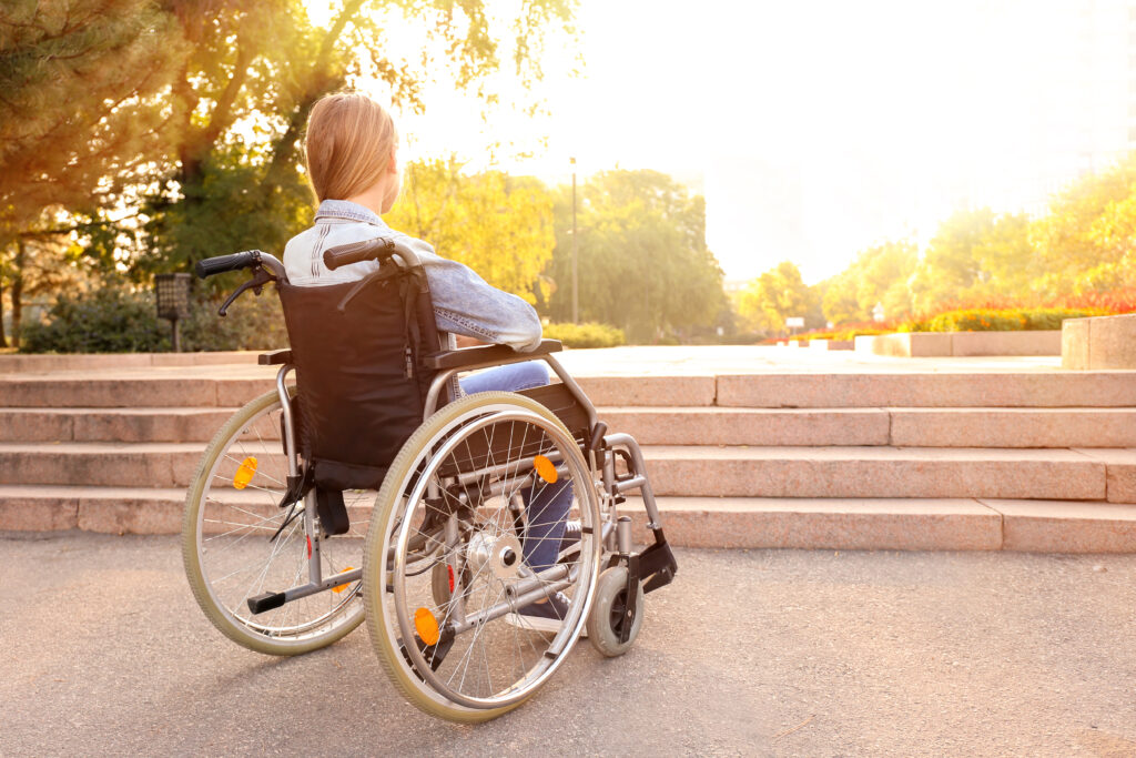 Girl in wheelchair near stairs outdoors