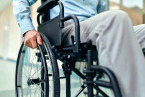 Close up of disabled elderly man sitting in wheelchair being car